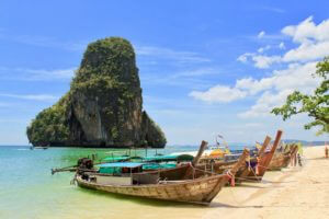 Thai longboats in a gorgeous sea in front of a karst mountain