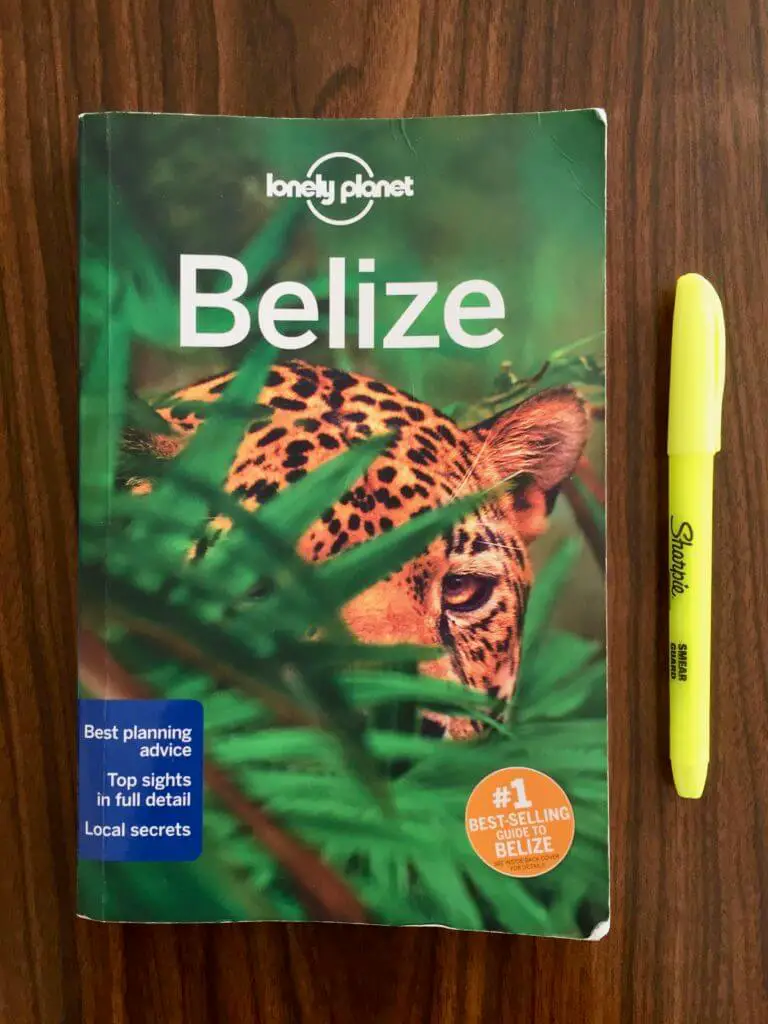 Belize Lonely Planet guidebook on a wooden table with yellow highlighter
