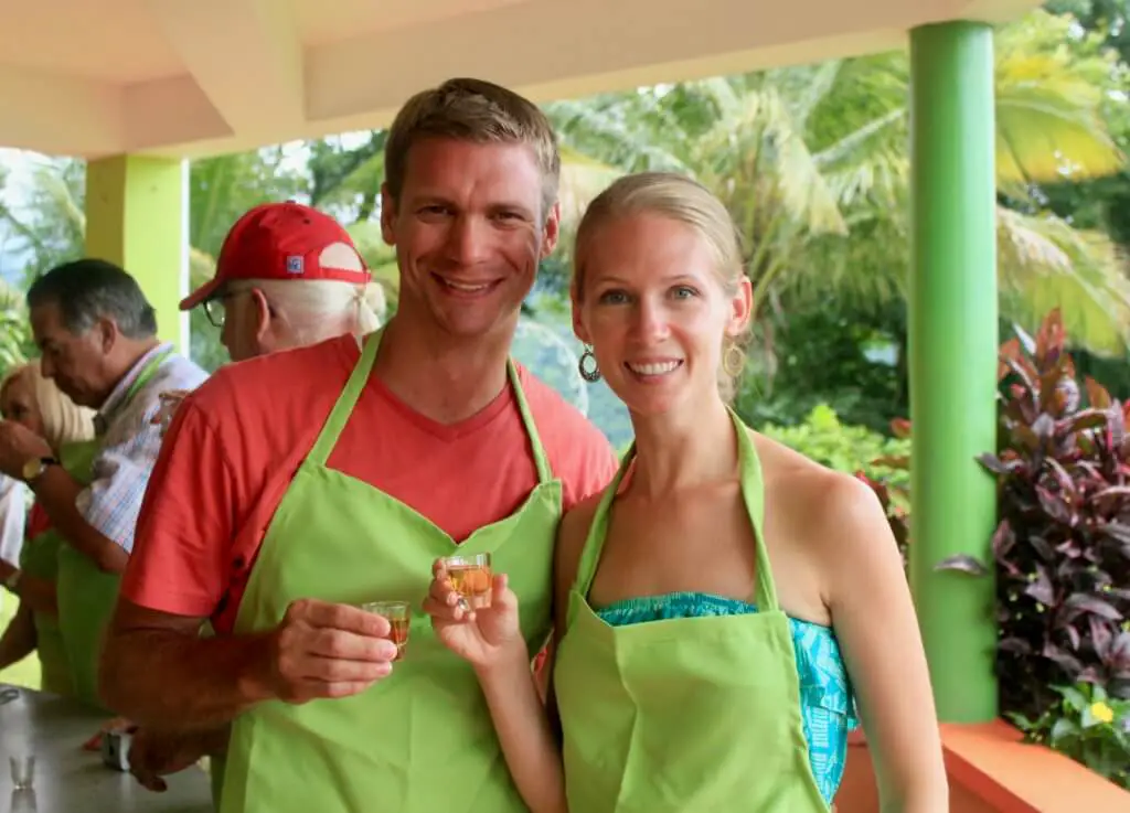 M and Gwen toasting in green aprons in a Dominica cooking class