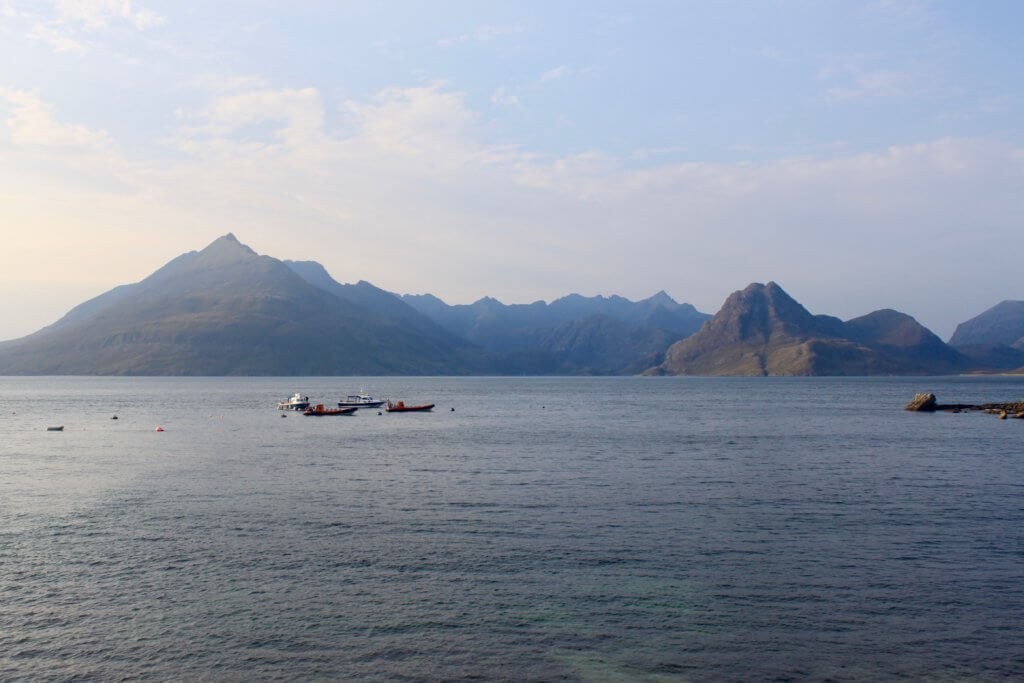 boats on the water with mountains beyond