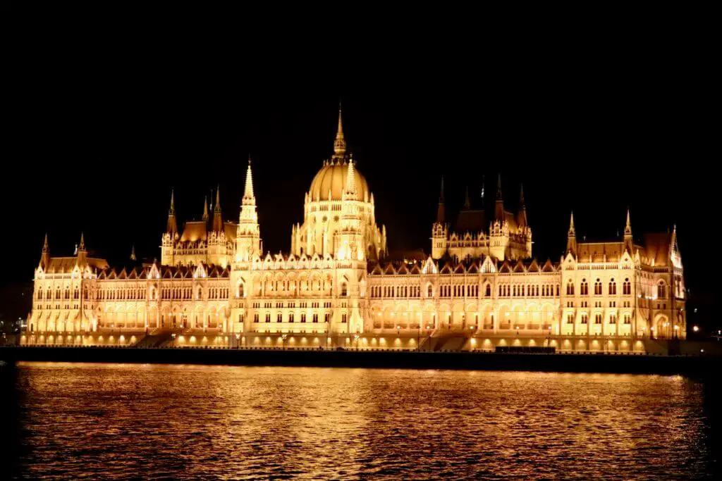 Parliament Building glowing golden, lit up at night in Budapest