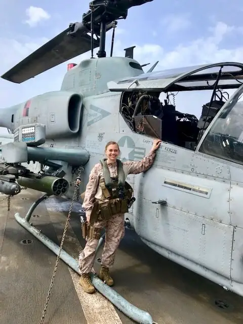 Ellen in military fatigues standing beside a helicopter