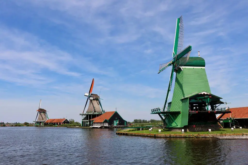 Three colorful windmills along the water in Zaanse Schans