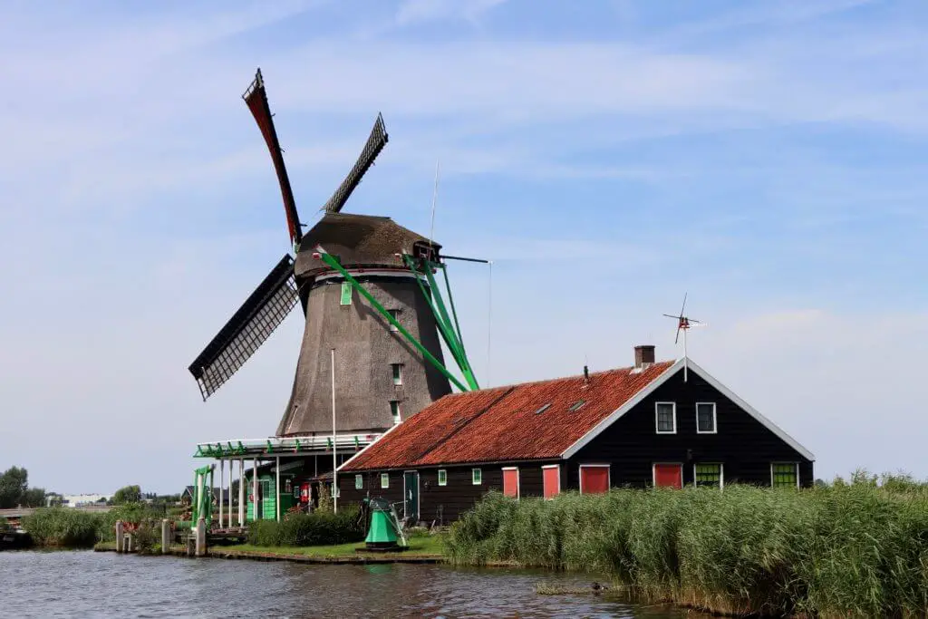 Windmill with red roofed building beside