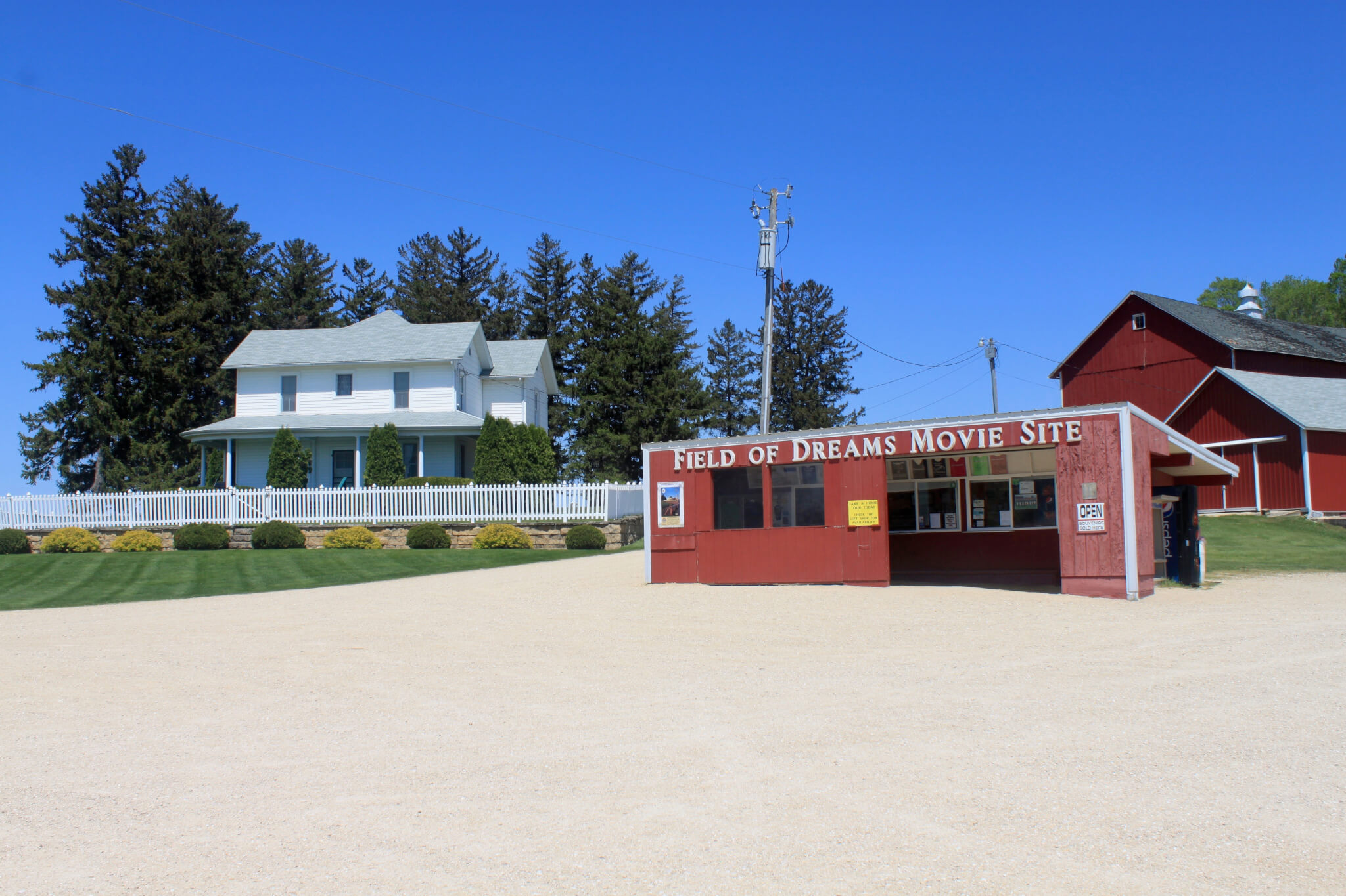 The white farm house and red barn from Field of Dreams movie with tourist shack in foreground