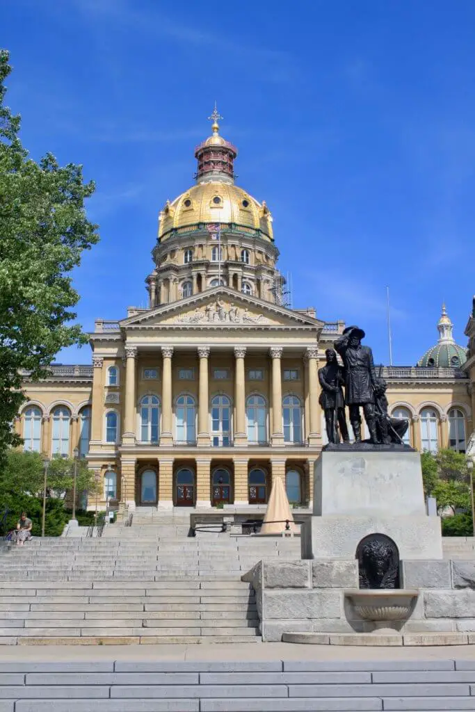 Front view of Iowa capitol building with golden dome and statue in front