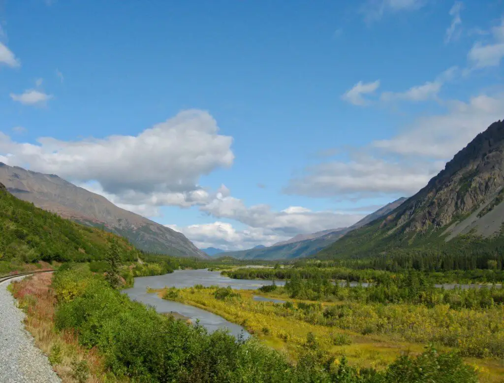 Glacial valley with river, mountains, and train tracks