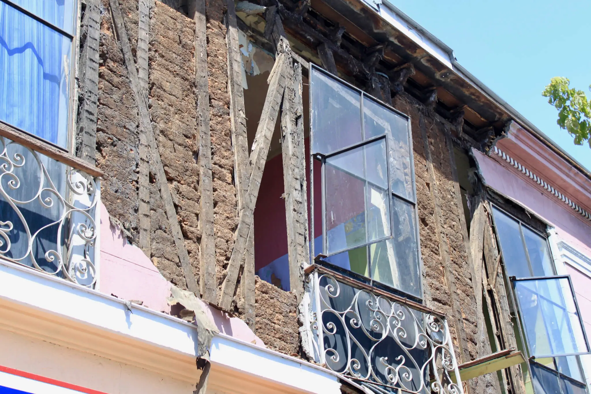 Broken window and brick building missing plaster after earthquake