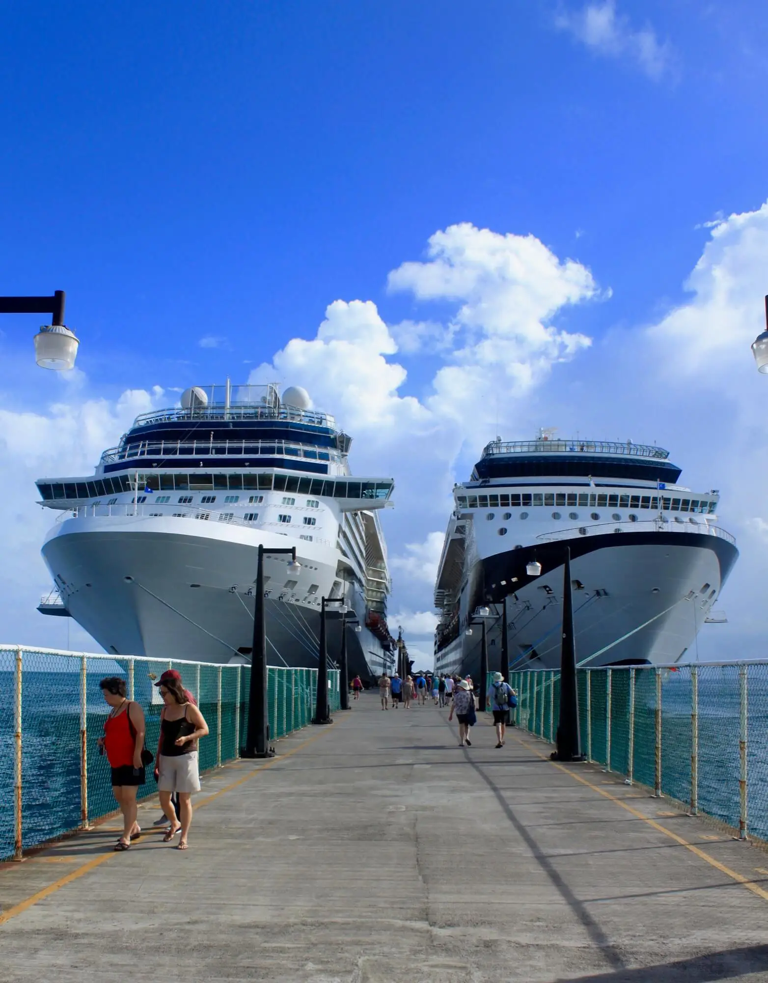 Two cruise ships docked at a cement dock