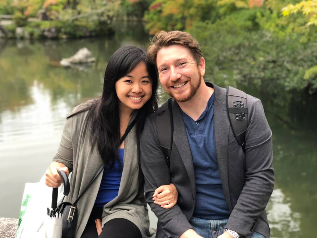 Erica and Jeff arm-in-arm in front of a lake