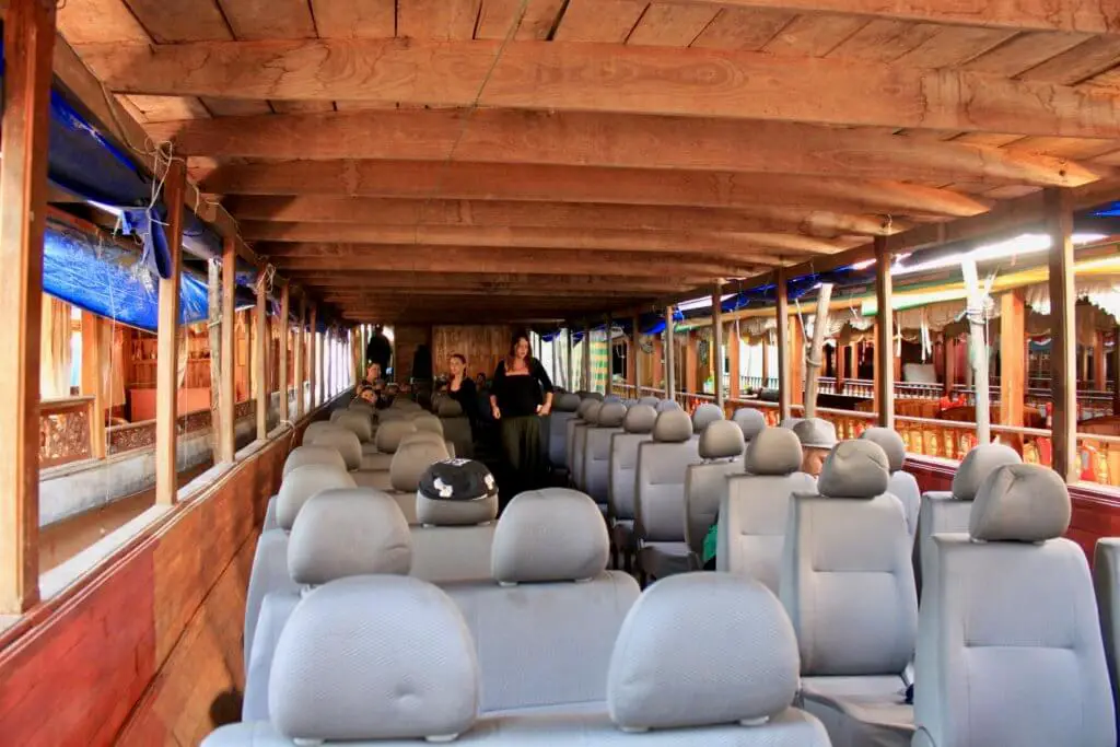 Interior of the longboat filled with rows of gray automobile seats. They're much more comfortable for a Mekong River cruise in Laos than the hard wooden benches of yesteryear!