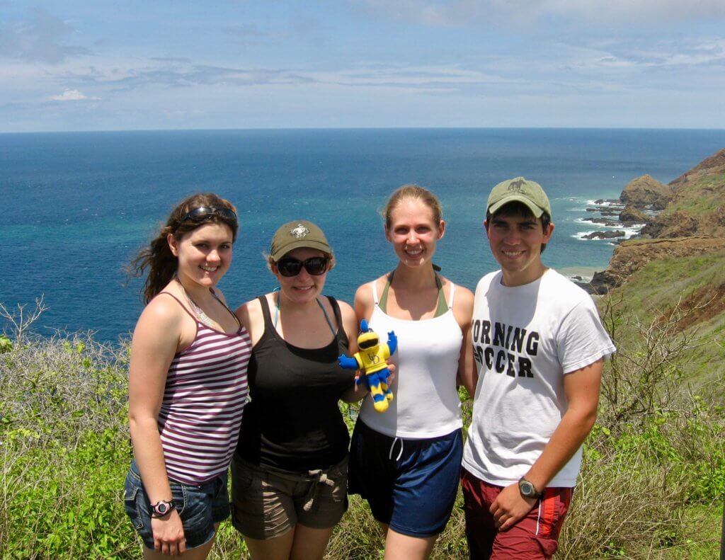 Group photo with green hills and blue water behind