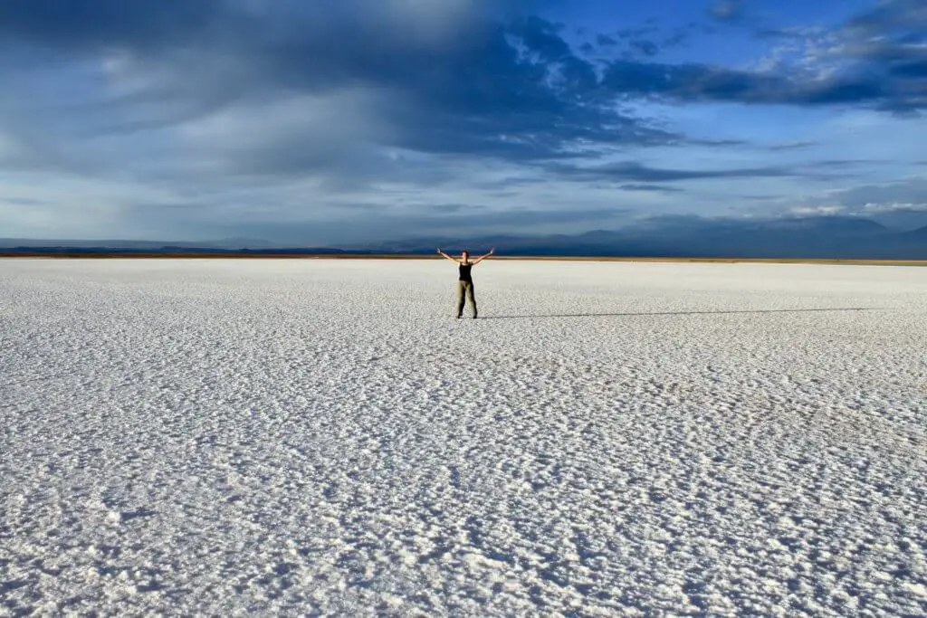 Gwen standing with arms spread wide in the middle of the salt flat