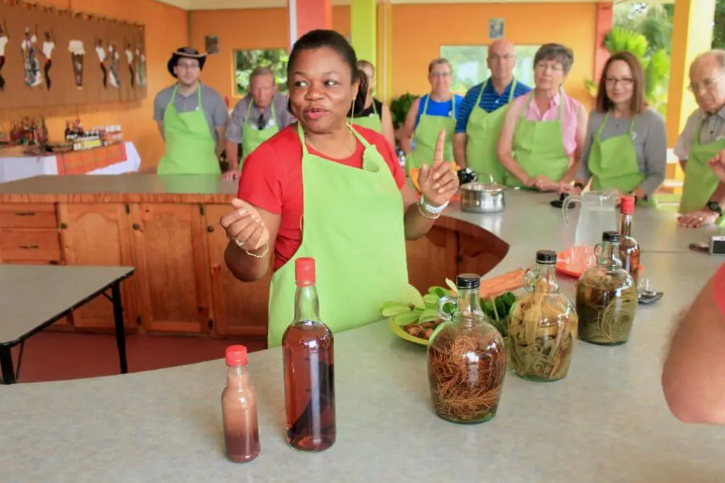 Woman in green apron describes the various rums on the table in front of her