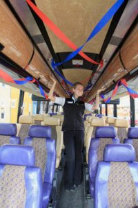 Gwen standing in a tour bus outfitted with red and blue streamers