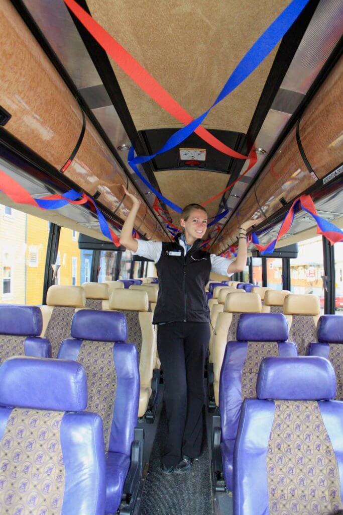 Gwen celebrating the 4th of July in Canada and standing in a tour bus outfitted with red and blue streamers