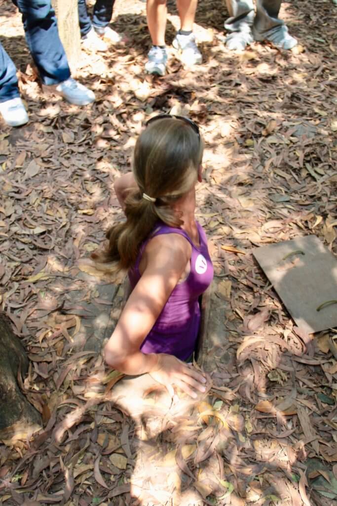 Gwen squeezing through the opening of a tunnel