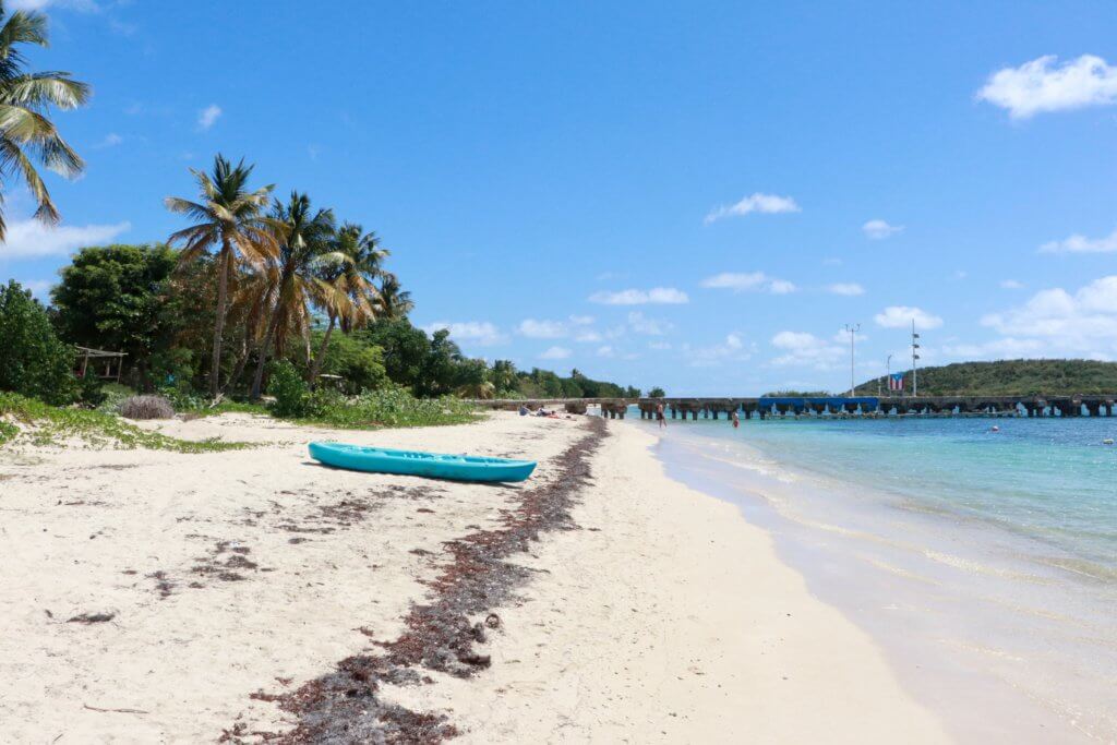 Blue kayak on Esperanza Beach, Vieques, with pier in background