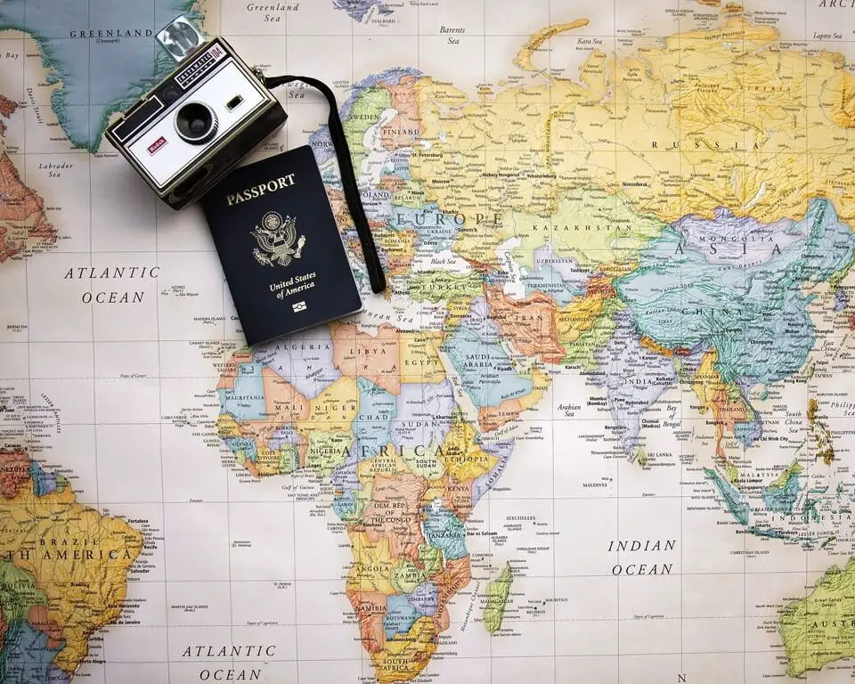World map with passport and camera