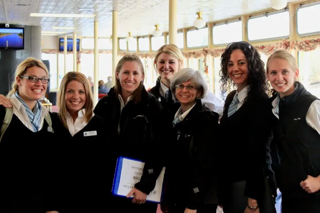 Seven female tour directors smiling in uniform