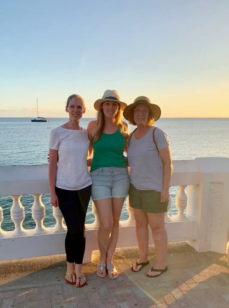 Gwen with her mom and sister in front of the ocean at sunset at our second mother-daughter trip destination: Puerto Rico