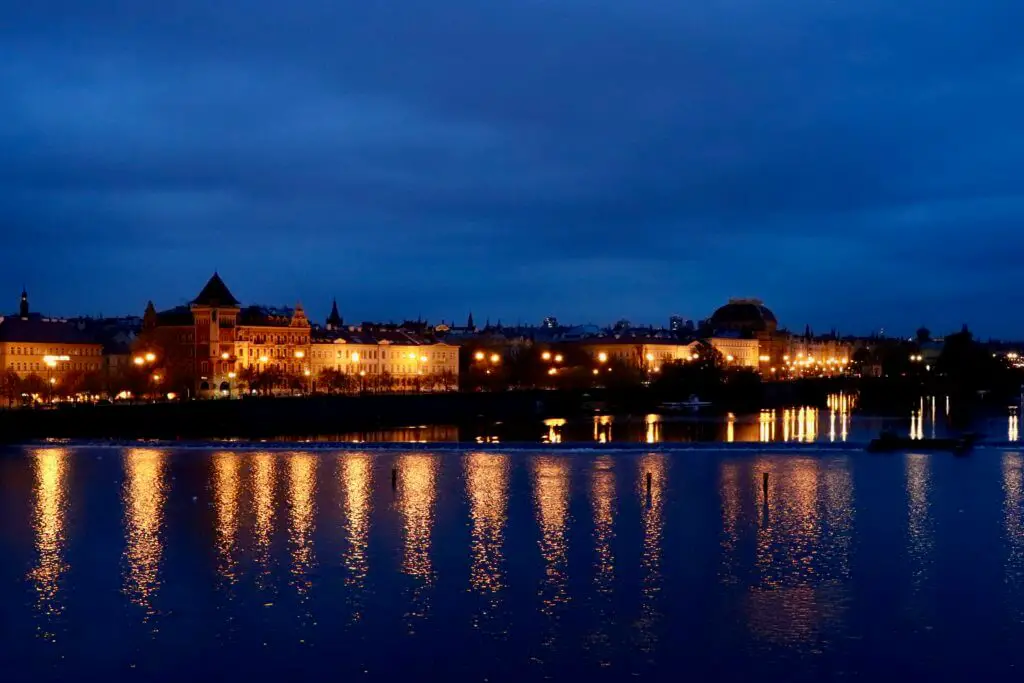 Prague riverfront lit up in the pre-dawn light