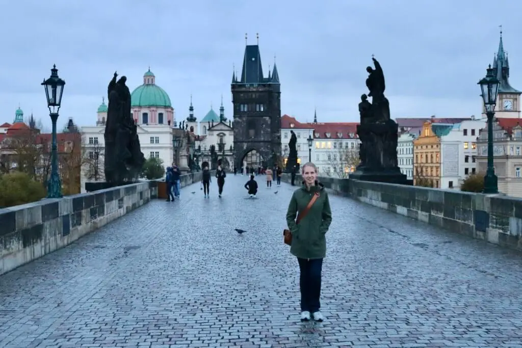Gwen on the nearly-empty Charles Bridge as dawn transitions to morning.