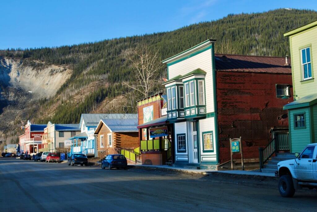 Colorful buildings of Dawson City with hillside beyond