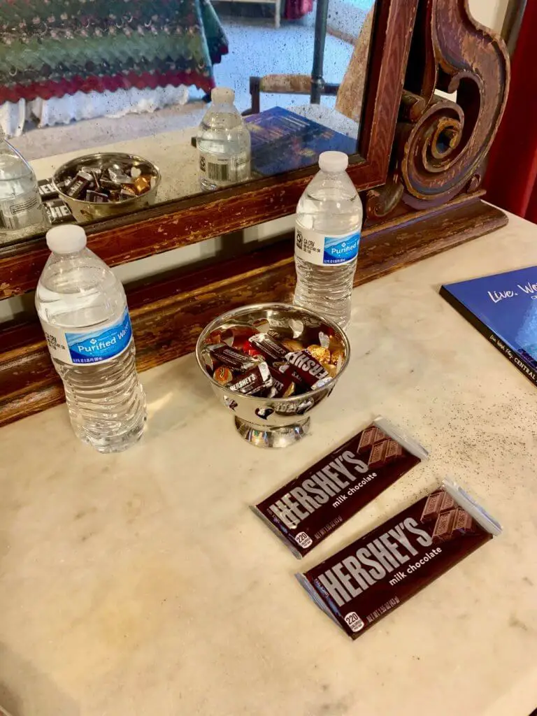 Two water bottles, two Hershey bars, and a bowl of miniature Hershey candies