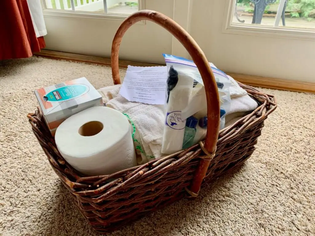 Basket of goodies, including toilet paper, tissues, towels, and toiletries