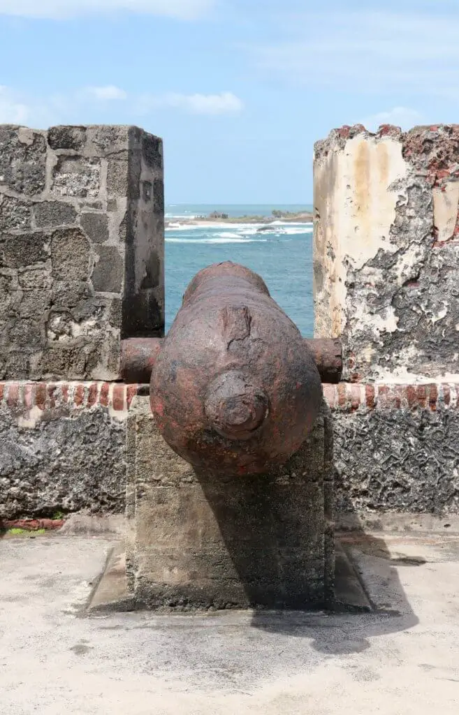 Cannon pointing through the battlements toward the ocean
