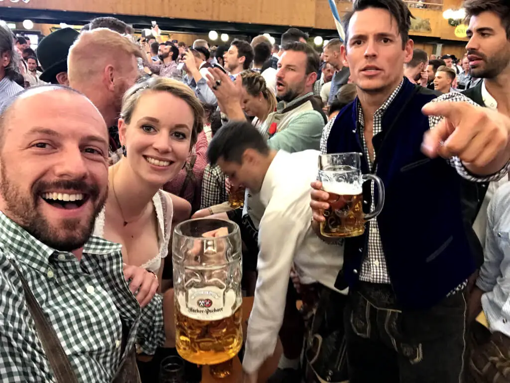 Max holding a beer with friends at Oktoberfest in Germany