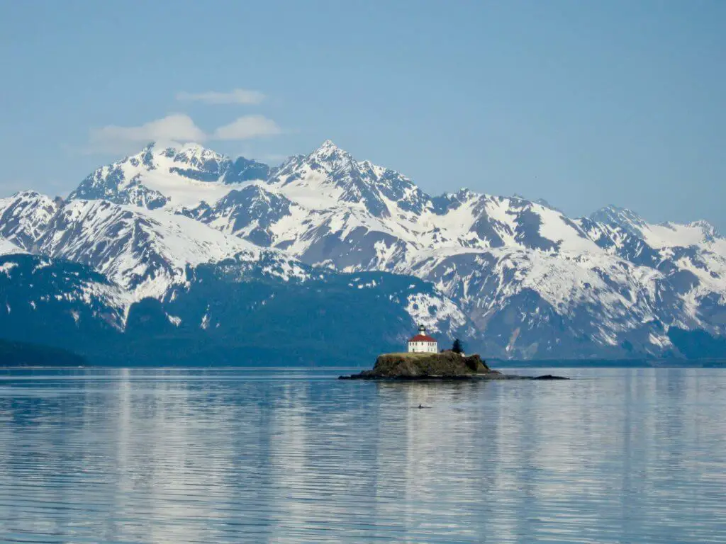 Lighthouse in front of snow-capped mountains
