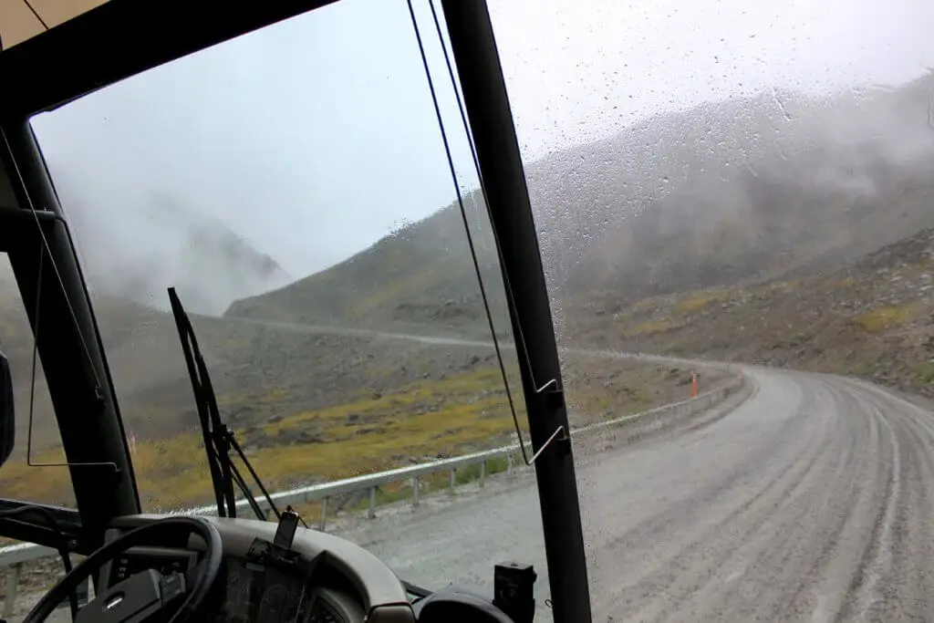 View through the front windows of a motor coach driving the Dalton Highway through the Brooks Range