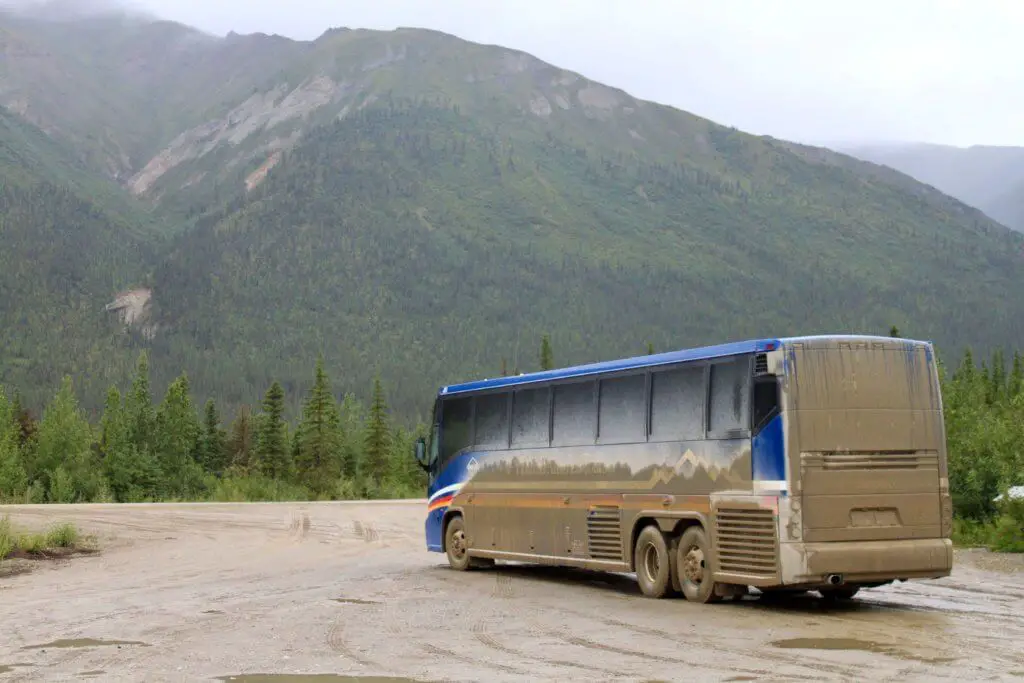Motorcoach caked with mud from driving Alaska's Dalton Highway