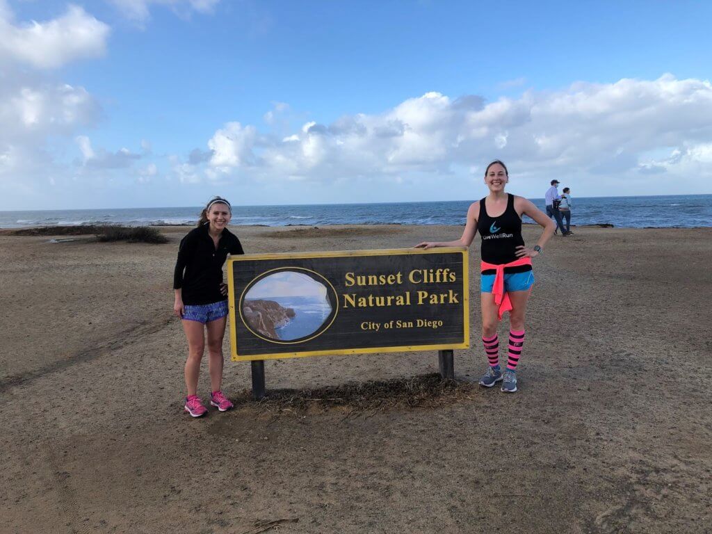 Friends posing by the Sunset Cliffs sign
