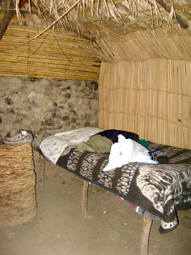 Inside the bamboo hut: a rustic bed with blankets