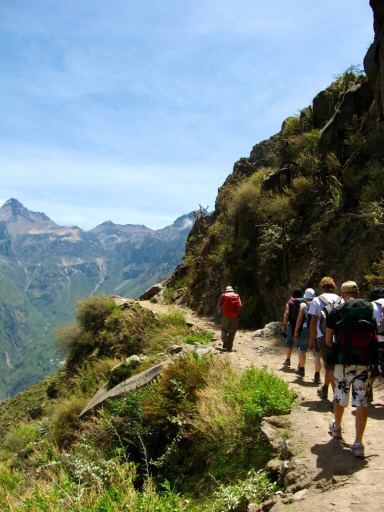 Line of hikers on a trail along the canyon wall