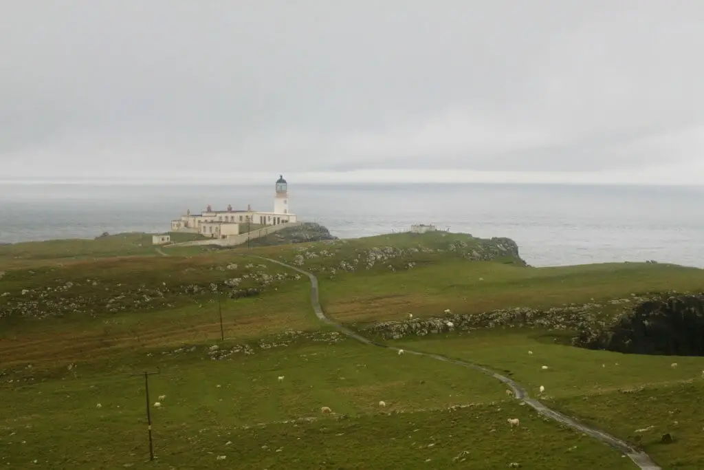 The Neist Point Lighthouse in the distance on a gray and gloomy day