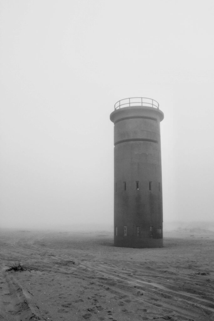 Black and white photo of a World War II watchtower in the sand