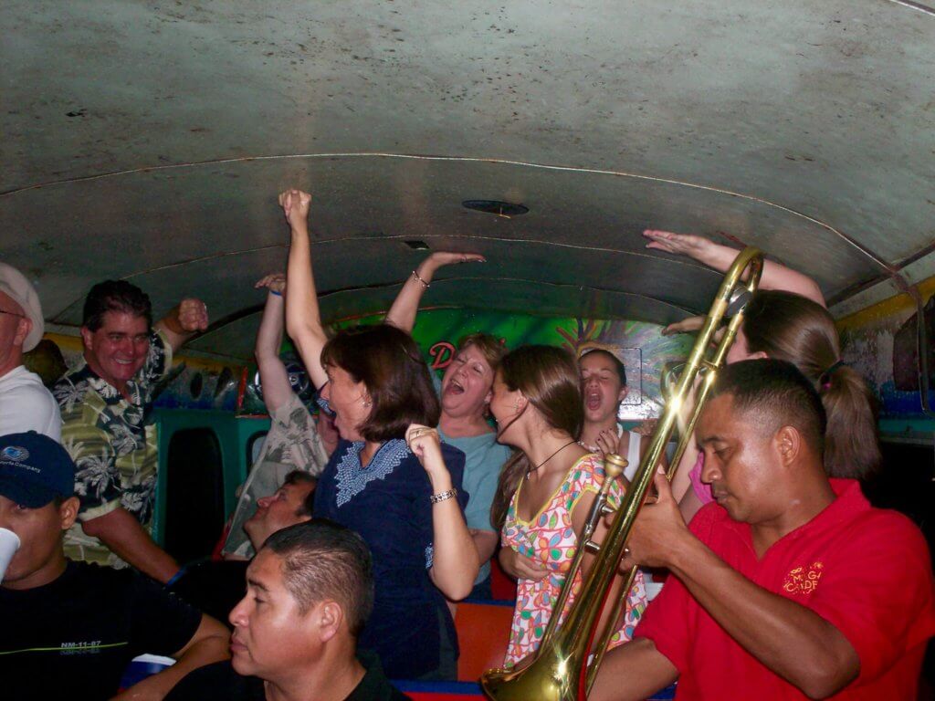 Trombone player and family dancing and singing on the chiva