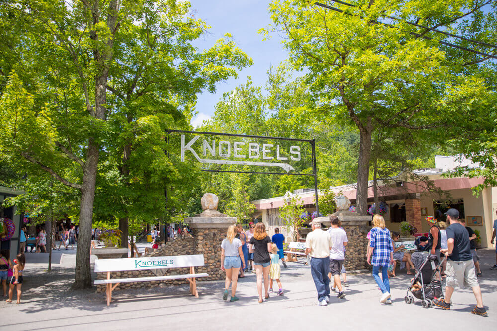 Entrance to Knoebels Amusement Resort, with trees and park bench.