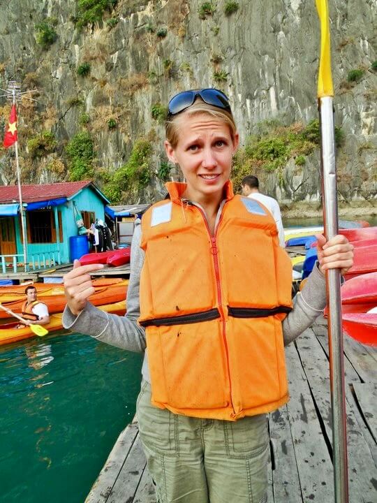 Gwen pointing and looking skeptical while wearing an old, flat life vest