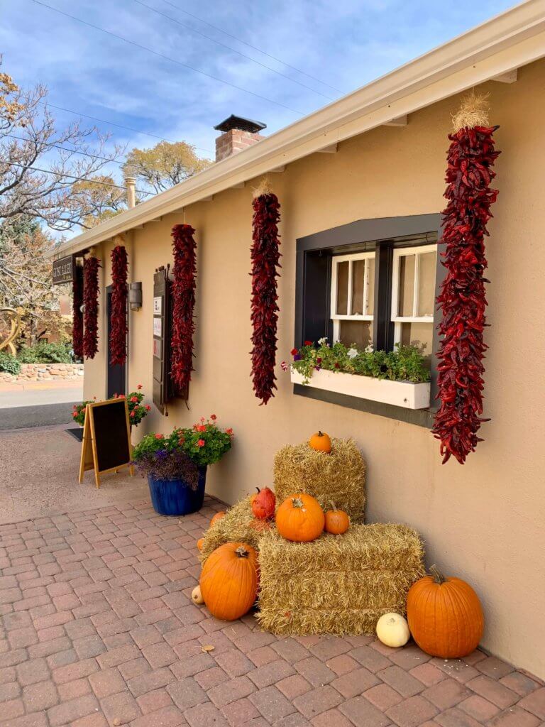 Exterior of an adobe building in Santa Fe with hanging chiles