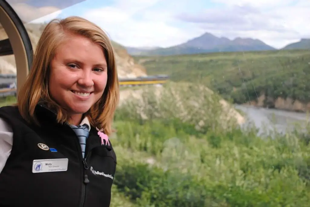 Molly in a tour director uniform in front of an Alaskan landscape