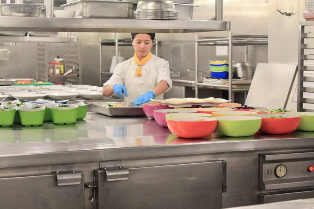 Woman working in a cruise galley. When planning a cruise, consider all the fun things there are to do onboard!