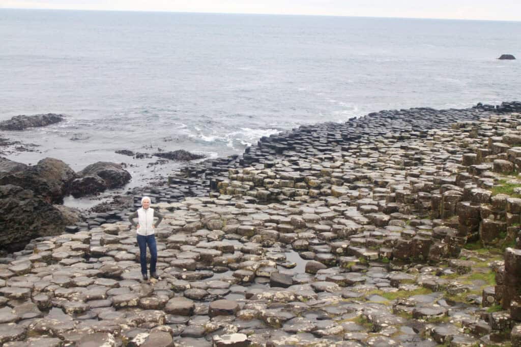 Gwen on the Giant's Causeway with ocean behind