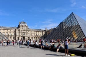 Exterior of the Louvre in Paris with glass pyramid in foreground